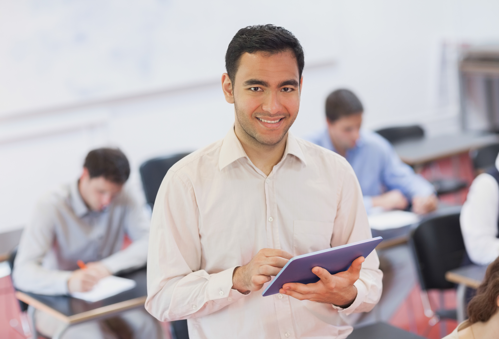 His class. Teacher Tablet. Teacher holding.